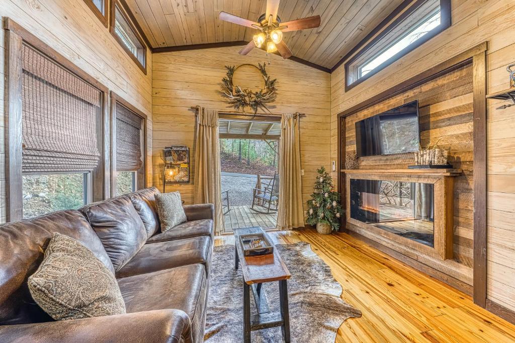 Leather sofa, electric fireplace and French doors to the porch · © Mill Creek Tiny House