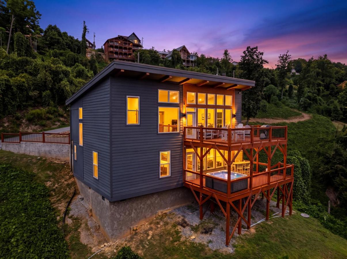 The modern cabin lit at dusk, hot tub on the lower deck · © The Modern Cabin on Beanstalk Road