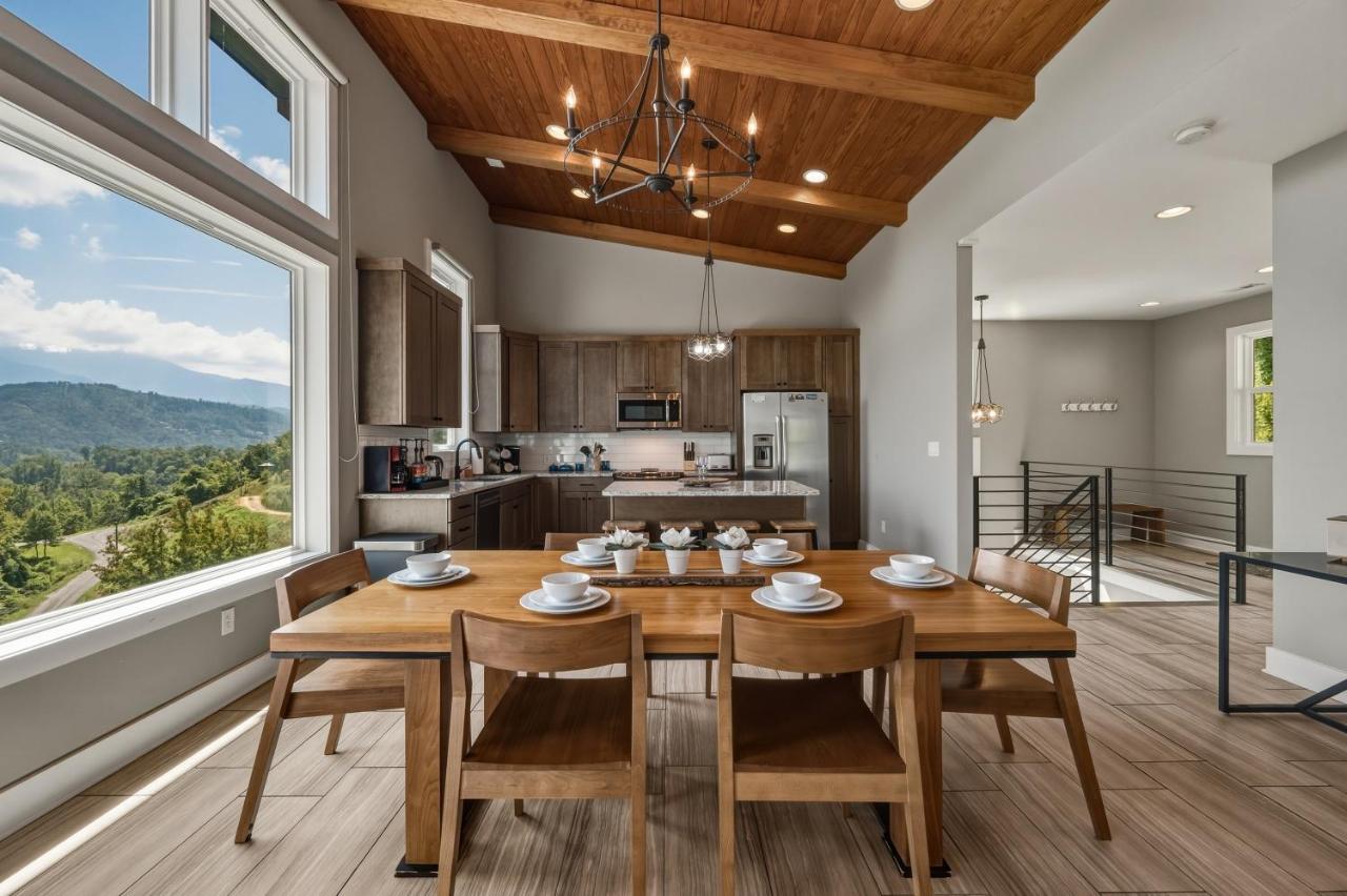 The dining table and kitchen under a vaulted wood ceiling · © The Modern Cabin on Beanstalk Road