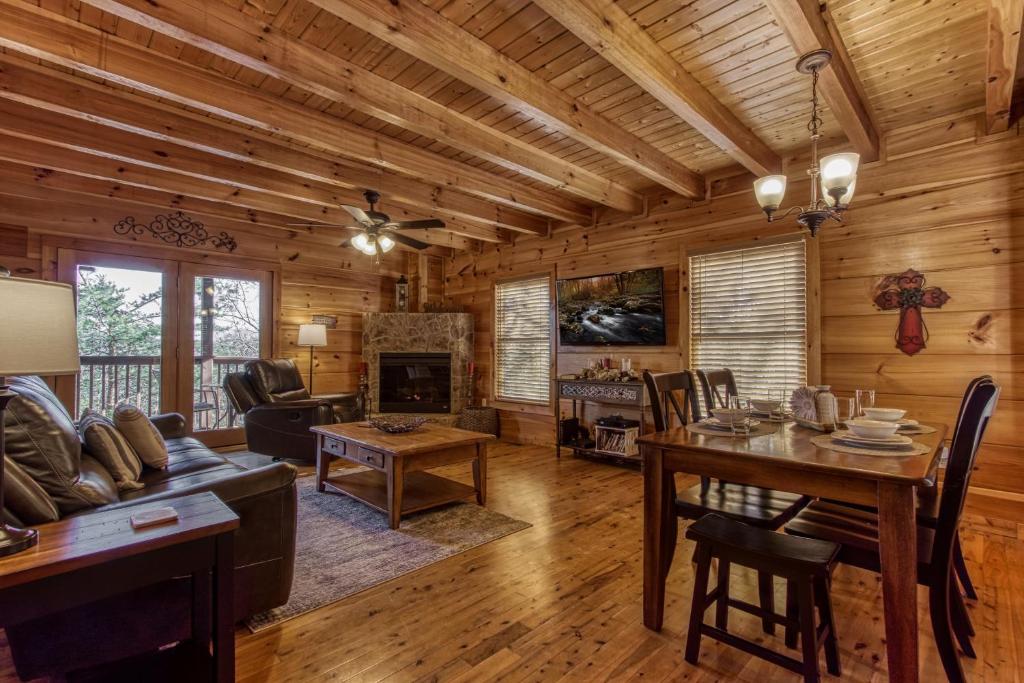 The beamed living room with its stone-framed fireplace and dining table · © Morning Glory