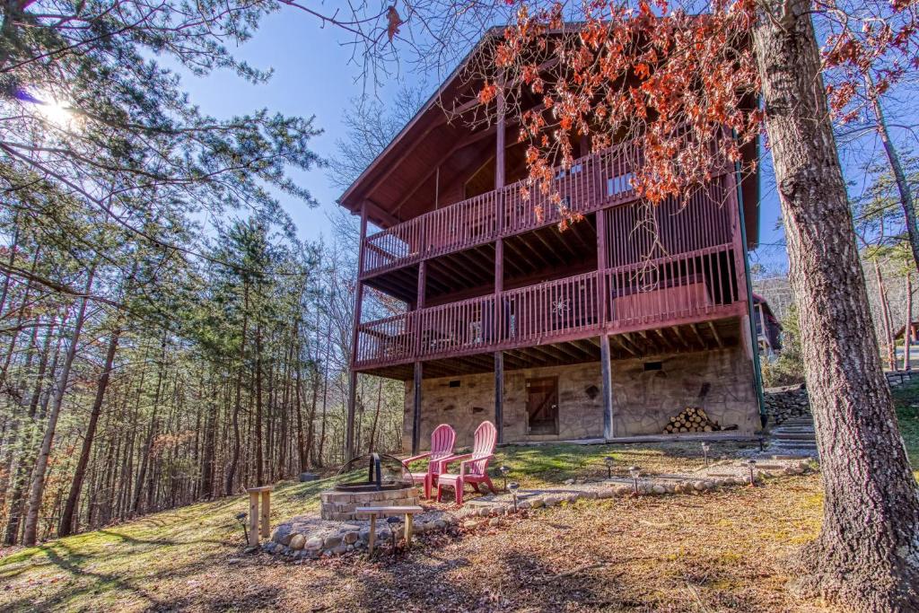 The cabin's stacked decks above the lawn and stone fire pit · © Morning Glory