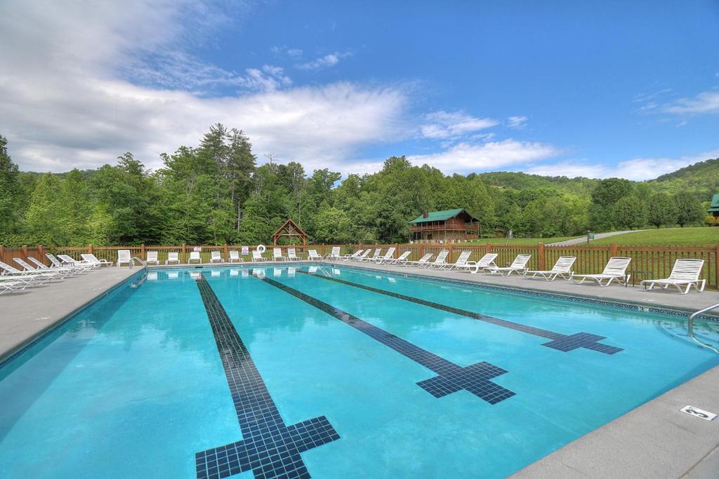 The large seasonal outdoor pool, lined with loungers · © Morning Glory