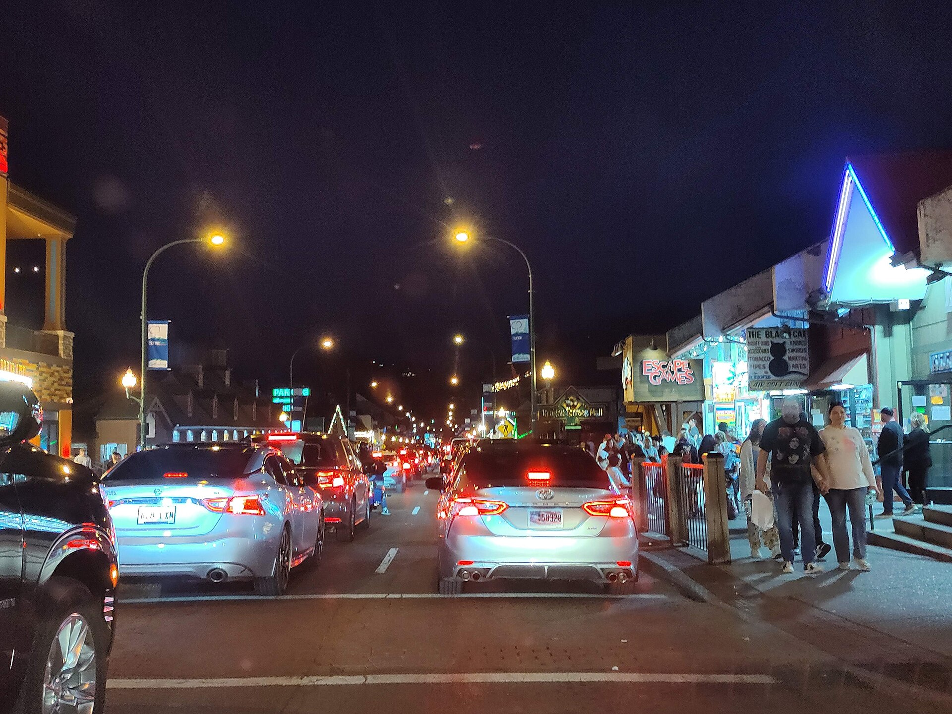Evening traffic and lit storefronts on the Parkway in downtown Gatlinburg