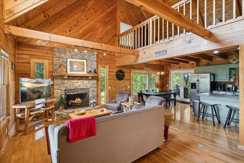 The great room's stone fireplace, open to the kitchen and loft · © Mountain Haven Cabin