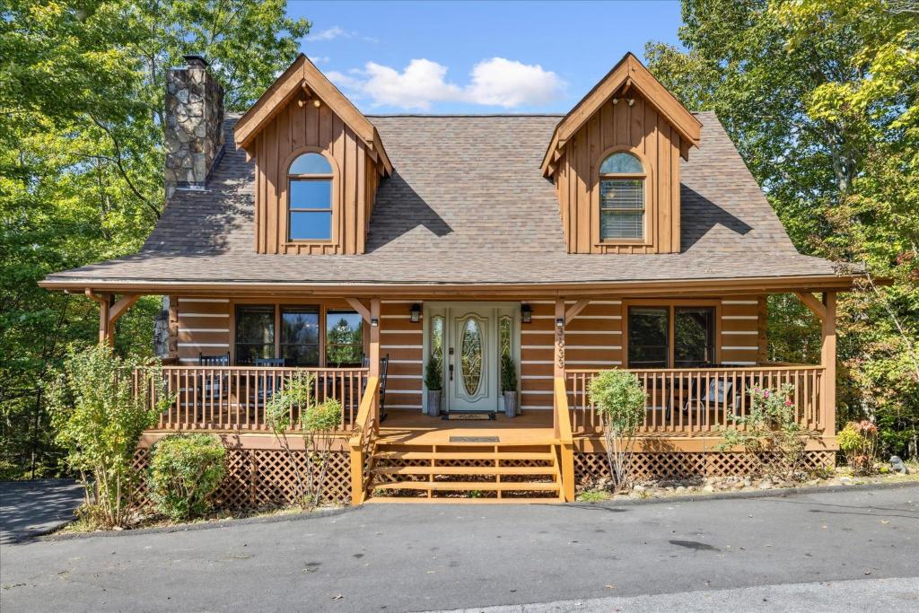 The log facade and front porch from the paved drive · © Mountain Haven Cabin