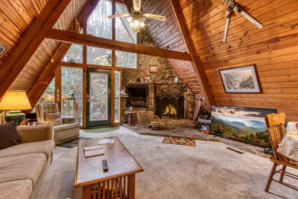 The living room under the pine gable, stone fireplace lit · © Mountain Springs Chalet