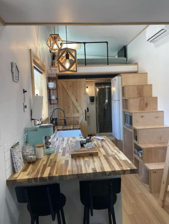 The butcher-block kitchen island, with storage stairs to the loft · © Mountain Top Tiny House