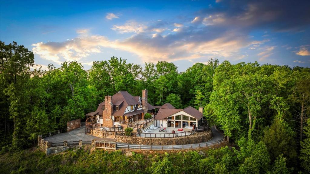 The house and its pool wing on a wooded hilltop · © Mountain View Mansion