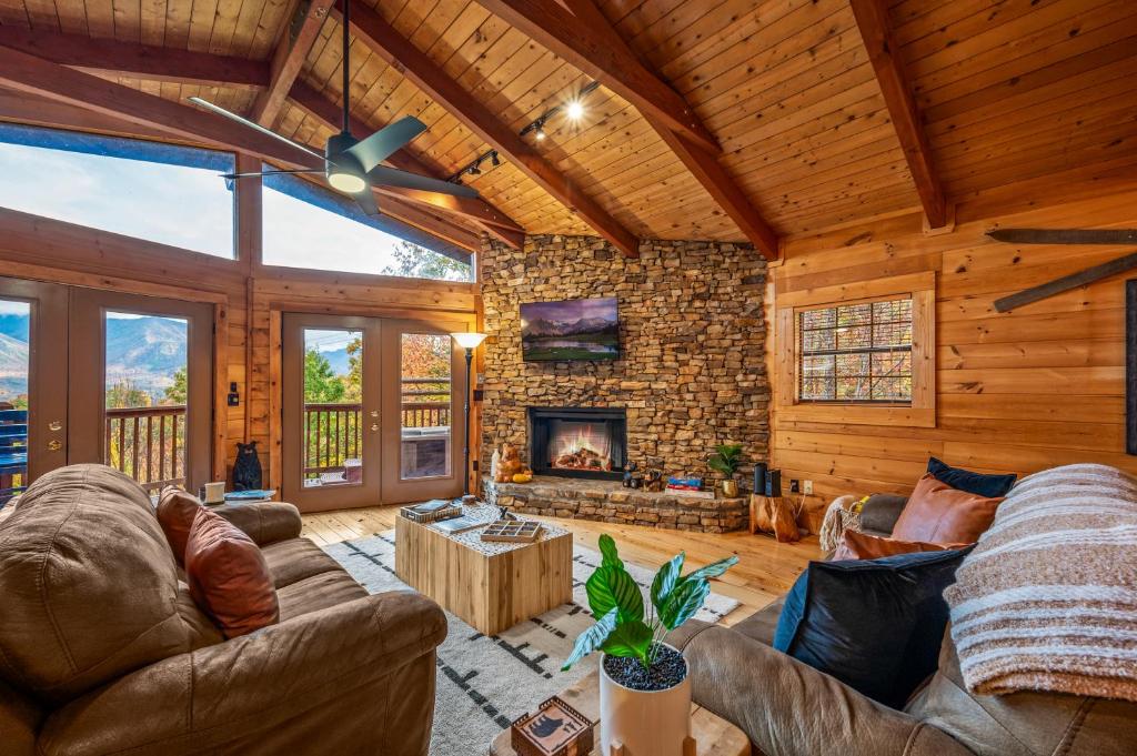 The great room under timber beams, fire lit in the stone hearth · © The Sauna Cabin on South Baden