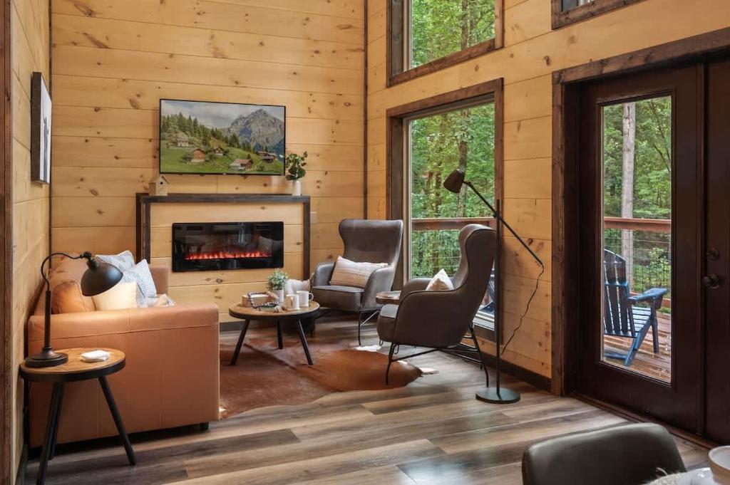 The living room's electric fireplace, armchairs and French doors · © Theo's Treehouse