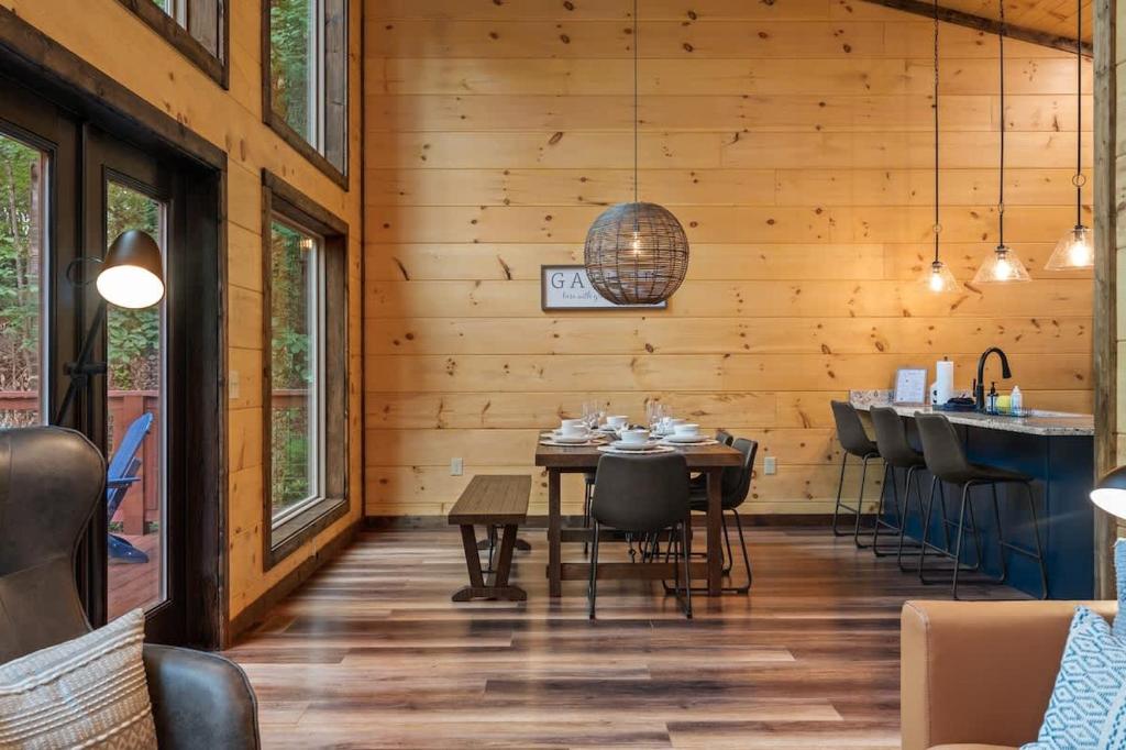 Dining table and kitchen island under a high pine ceiling · © Theo's Treehouse
