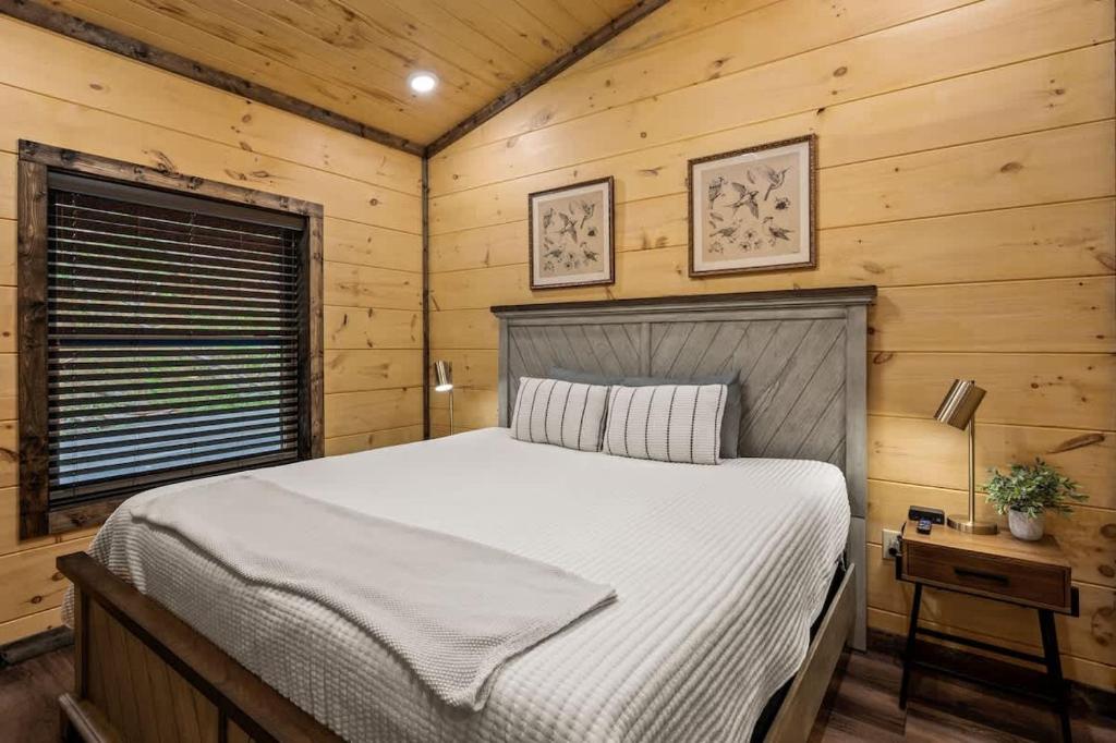 The king bedroom, pine-walled with bird prints above the bed · © Theo's Treehouse