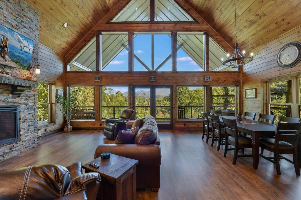 The great room's wall of windows, looking toward the peaks · © New Luxury Lodge