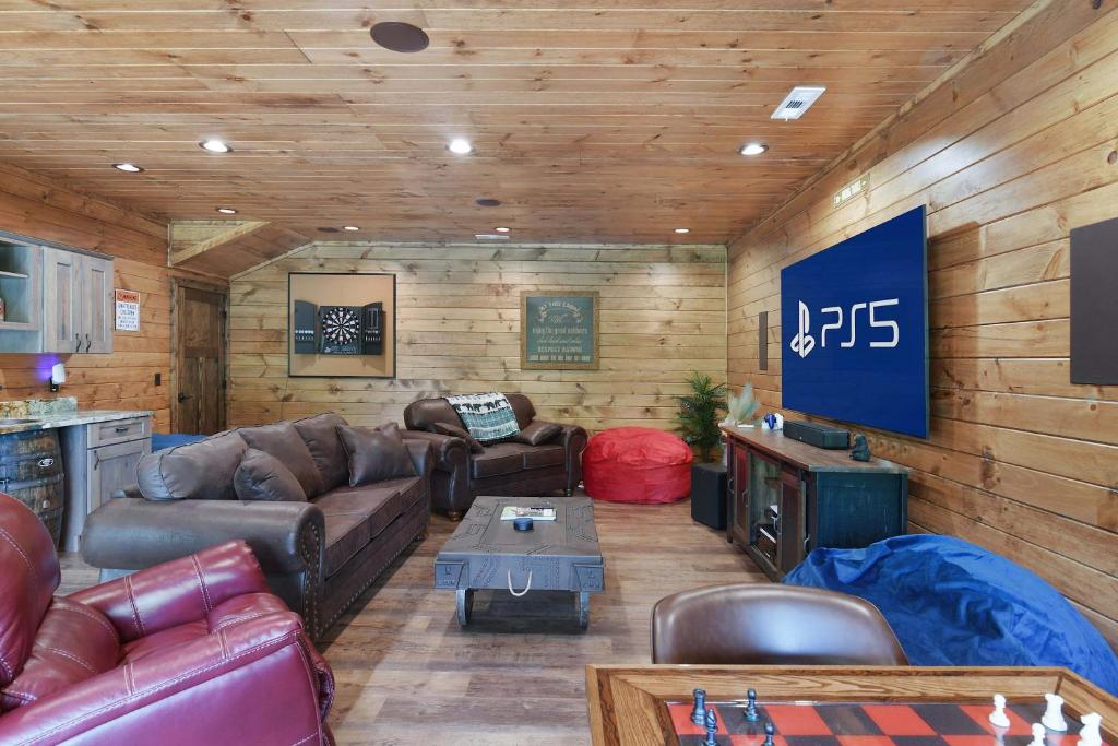 The game room, with a big screen, darts and a chess table · © New Luxury Lodge