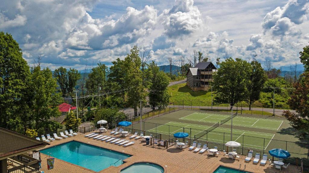 The shared pool complex, with a spa and courts beyond · © New Luxury Lodge