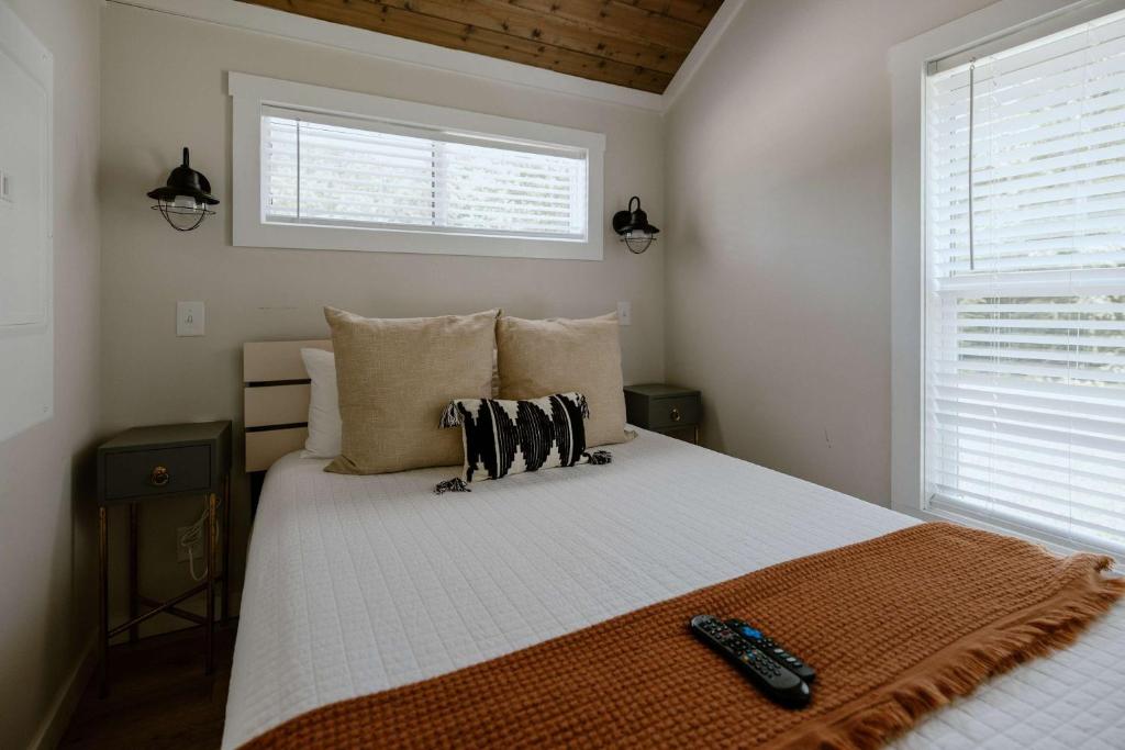 The main-floor queen bedroom with wall sconces and a wood ceiling · © Oak Cabin
