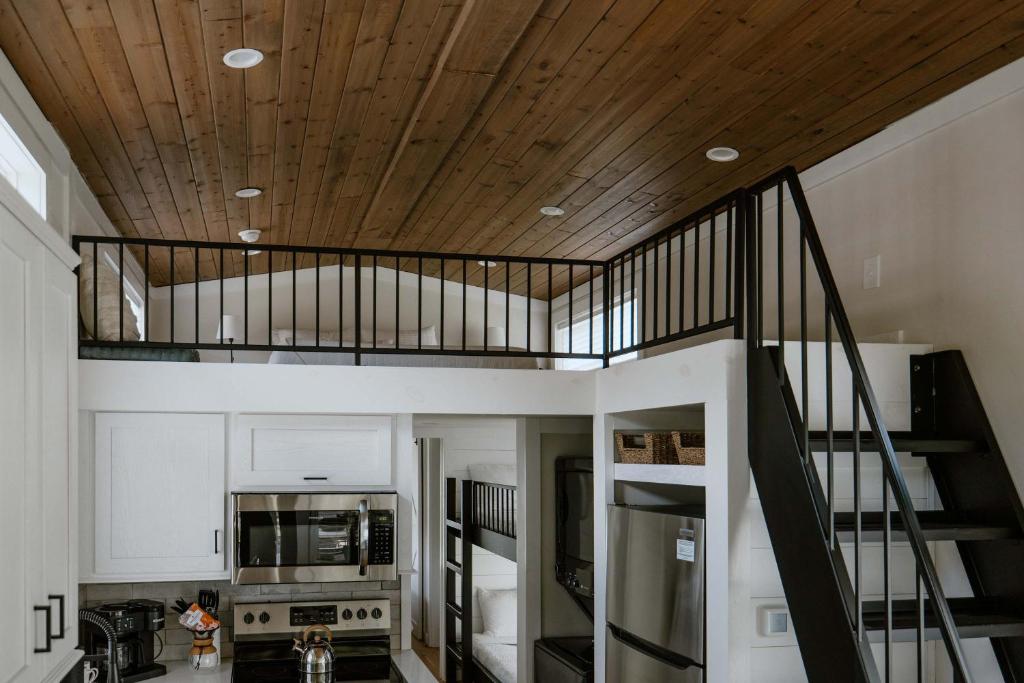 The loft rail, the bunk alcove and the steep stair beside the kitchen · © Oak Cabin