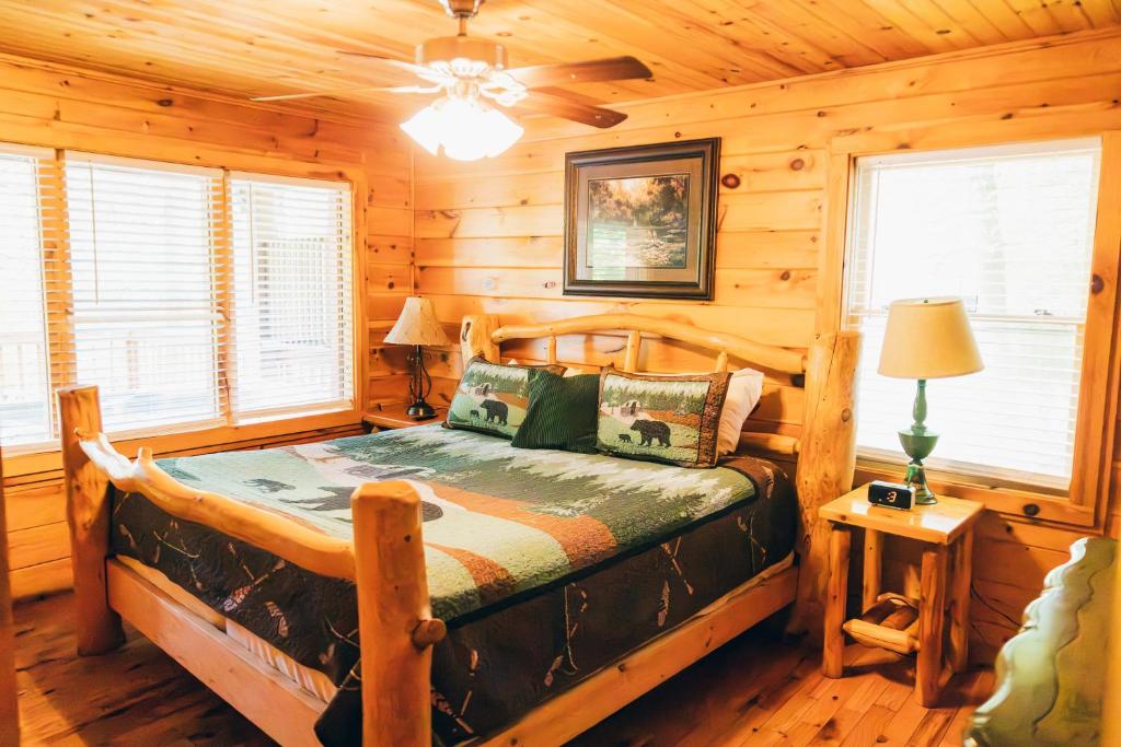 The king bedroom's log bed under a black-bear quilt · © Ole Red Retreat