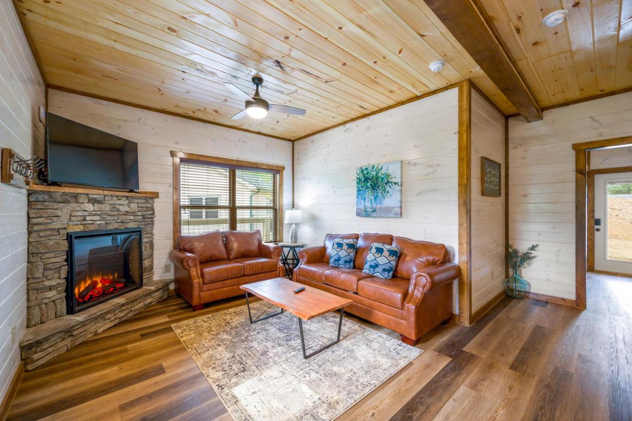 The living room with a stacked-stone fireplace and leather sofas · © Osprey Nest Cottage