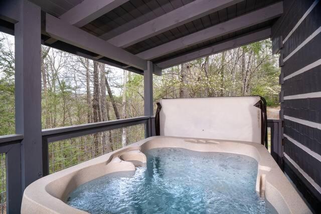 The hot tub on the covered deck above the woods · © Peaceful Escape