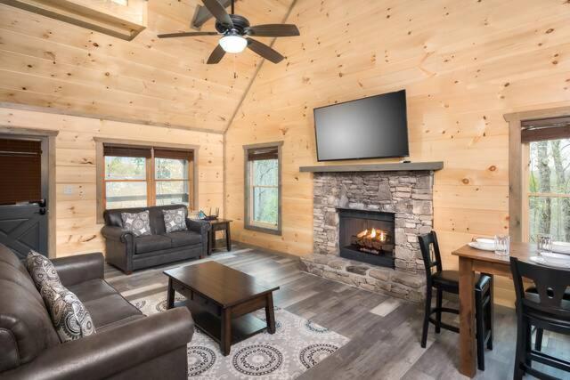 The pine-clad living room around a stone-faced fireplace · © Peaceful Escape