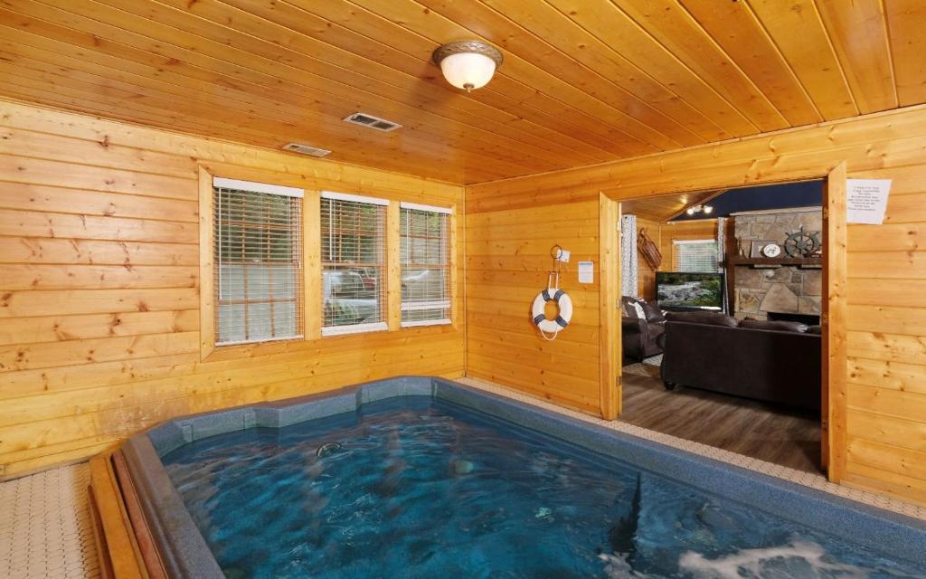 The indoor swim spa in its pine room, opening onto the living area · © Poolin Around