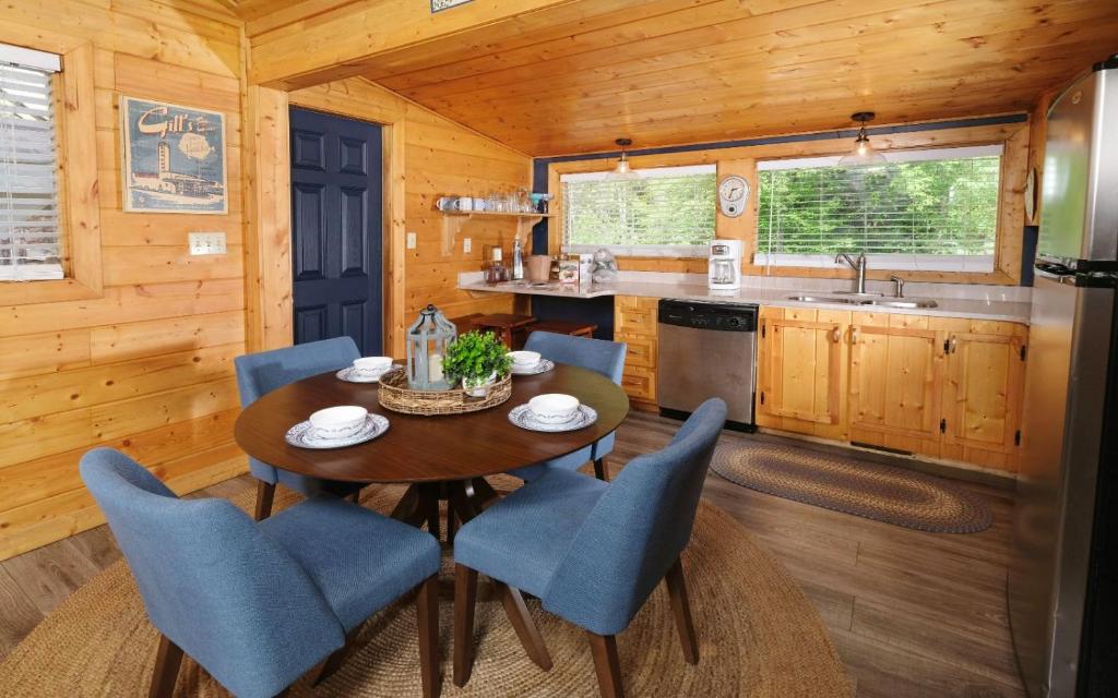 A round dining table beside the pine kitchen · © Poolin Around