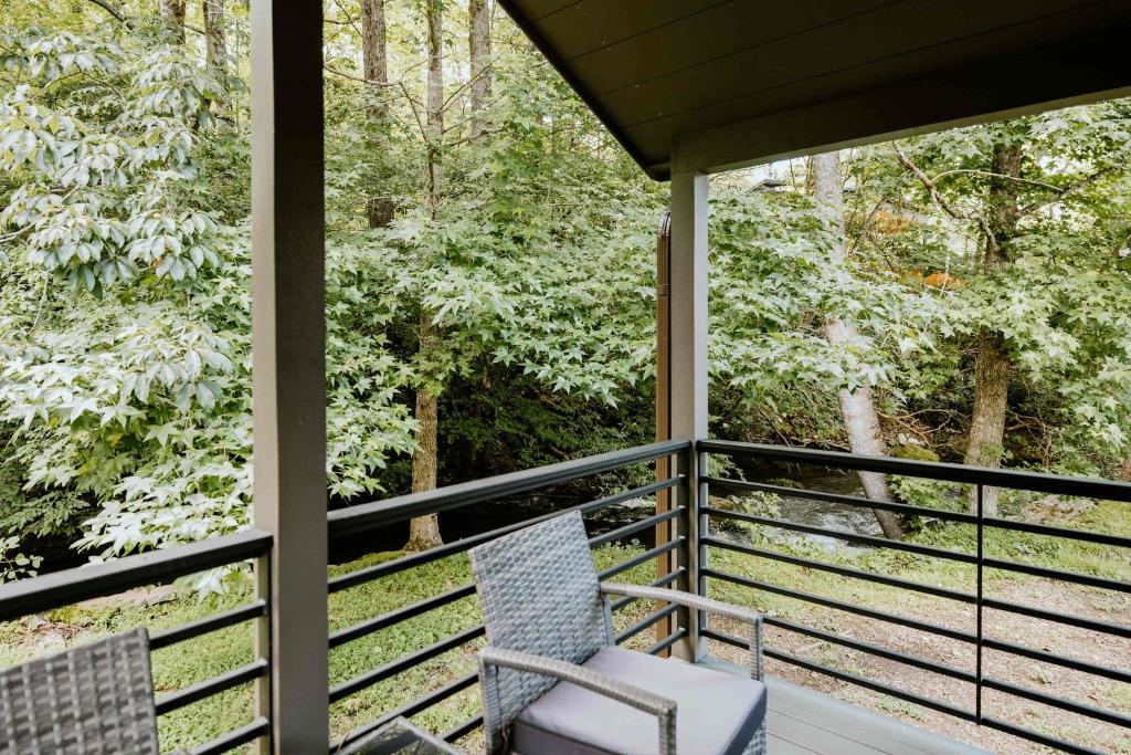 The covered porch looking through the trees to the creek · © Racoon Cabin