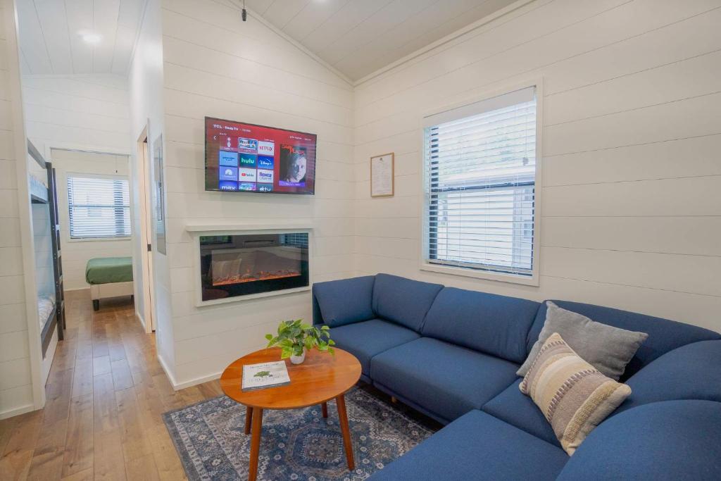 The living room, with electric fireplace and the bunks beyond · © Racoon Cabin