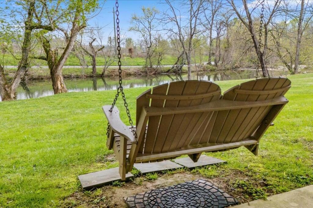 The porch swing on the lawn, set at the edge of the creek · © River Oar'asis