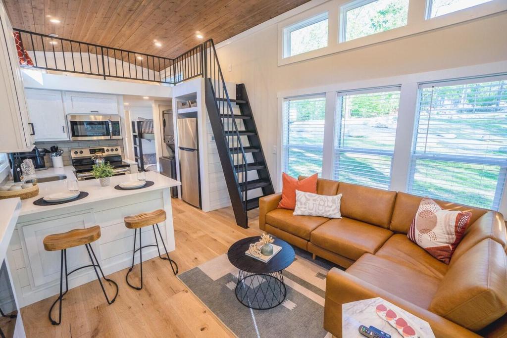 The open living room and kitchen, with the stair to the loft · © Sage Cabin