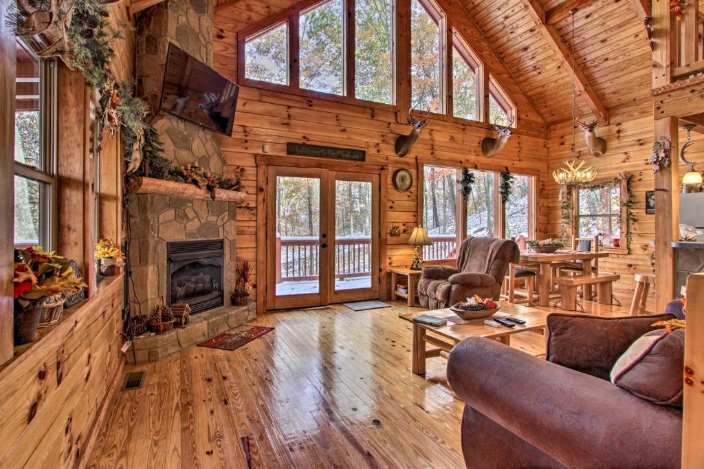 The living room's stone fireplace and French doors to the deck · © The Wraparound Deck Cabin