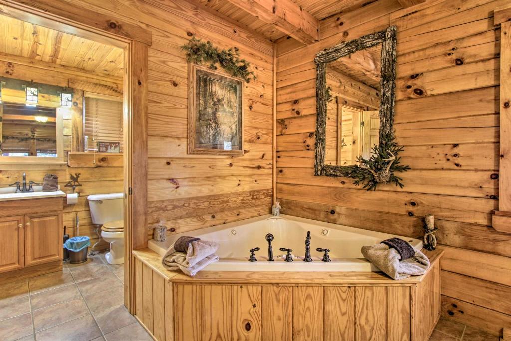 The jetted corner tub in its pine-panelled bathroom · © The Wraparound Deck Cabin