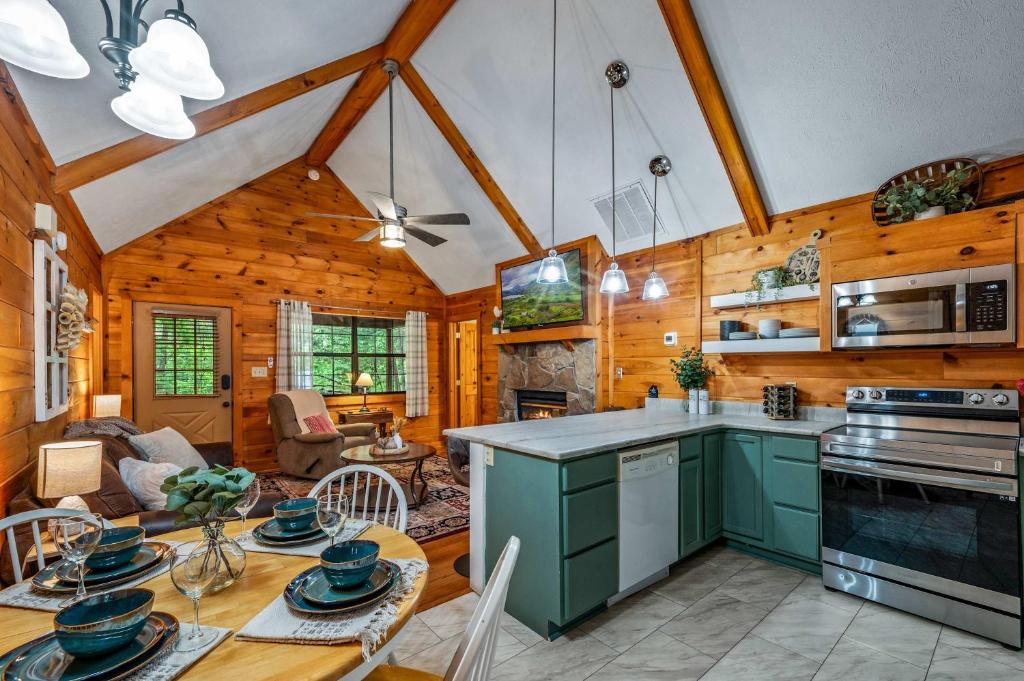 The dining table and green kitchen under the pine ceiling · © Serene Escape