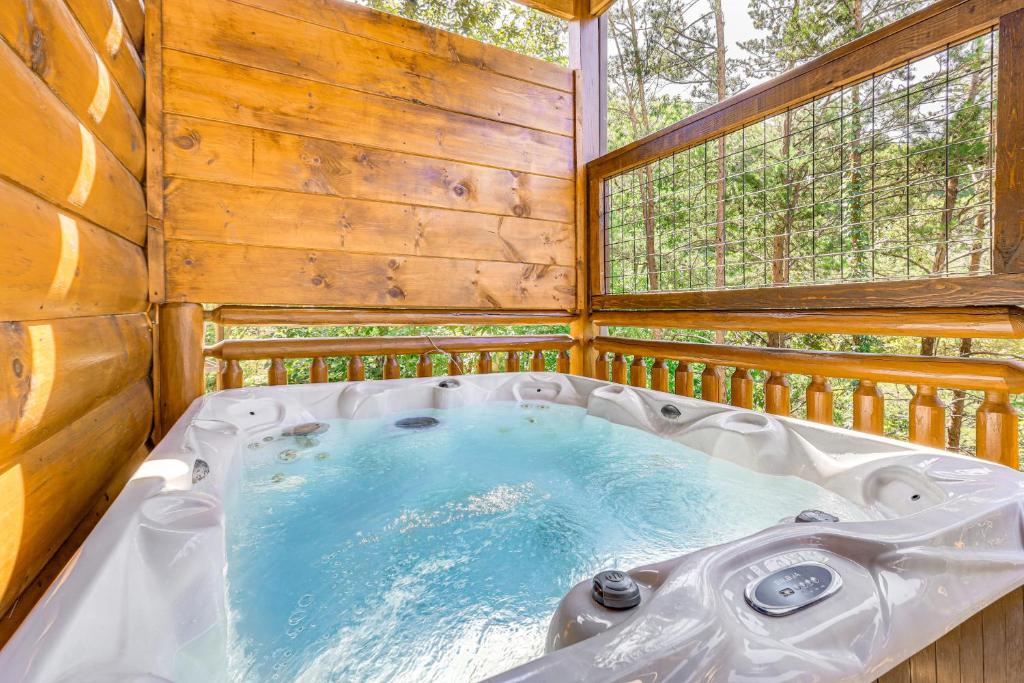 The private hot tub behind its privacy wall, trees beyond · © Shady Pines