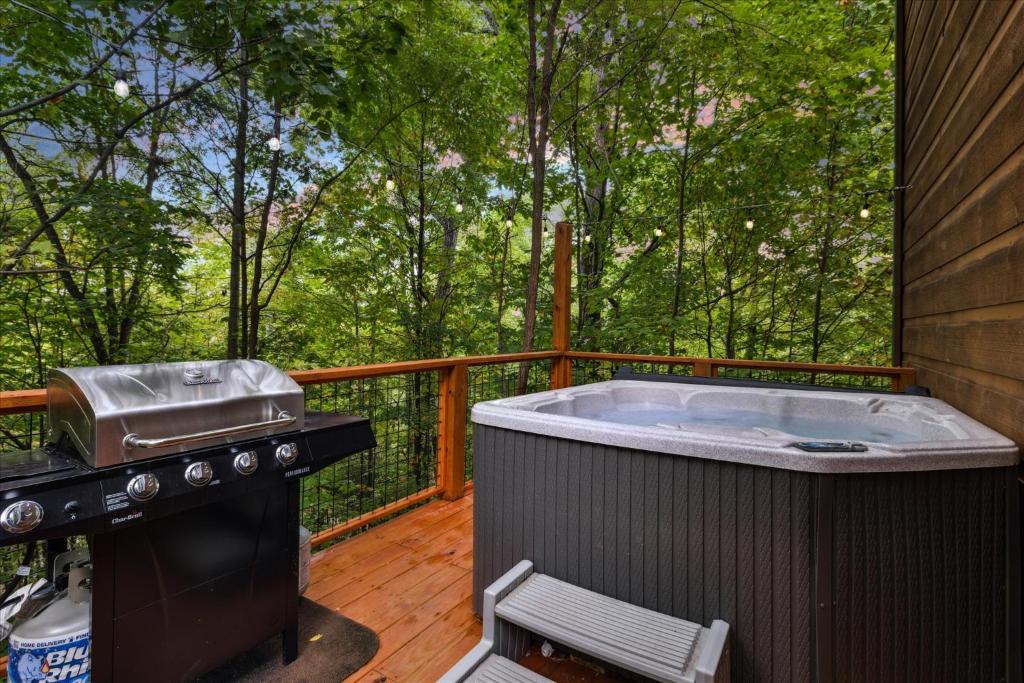 The private hot tub and grill on the side deck in the trees · © Smoky Oaks