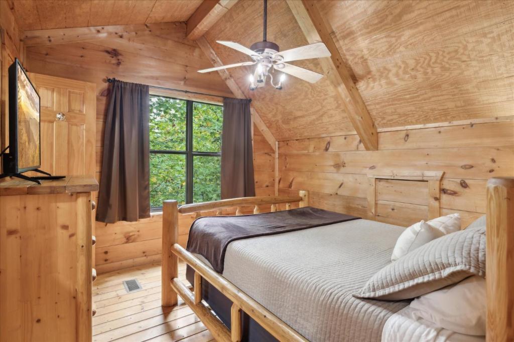 A log-frame bed under the vaulted ceiling and a ceiling fan · © Smoky Oaks