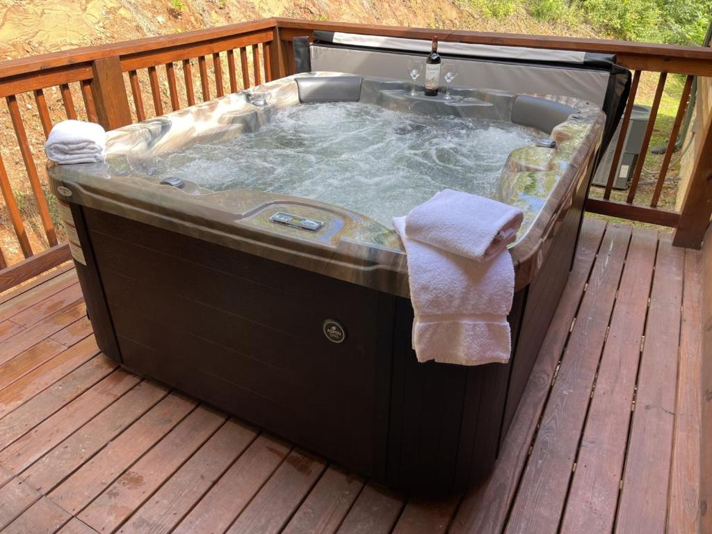The hot tub on the wooden deck, towels ready · © Smoky Retreat