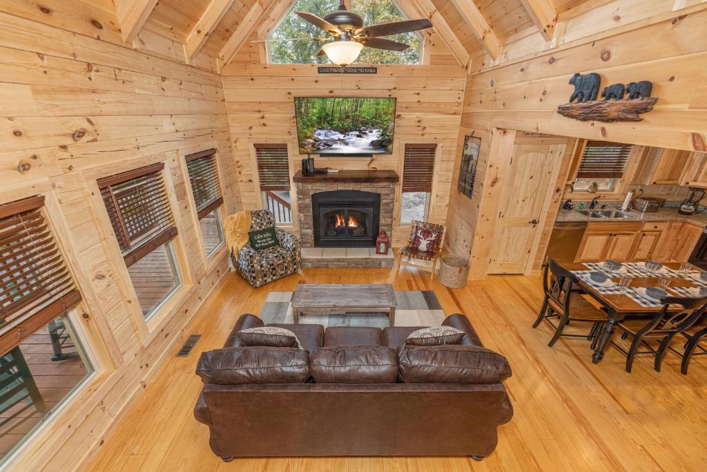 The living room, stone fireplace and dining table under pine beams · © Smoky Retreat