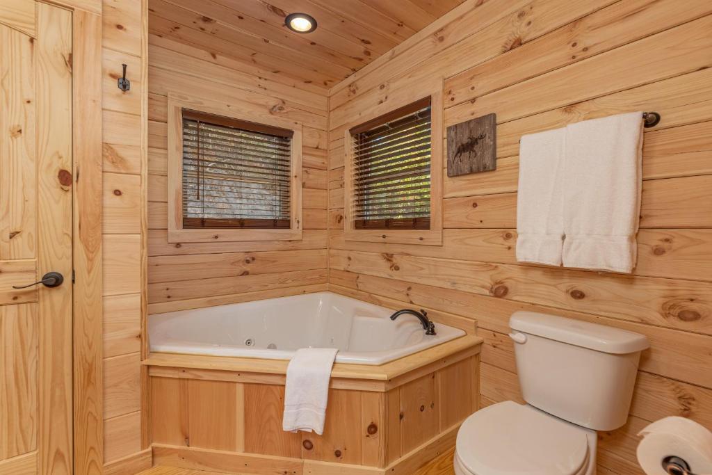 A corner jetted tub in one of the pine-clad bathrooms · © Smoky Retreat