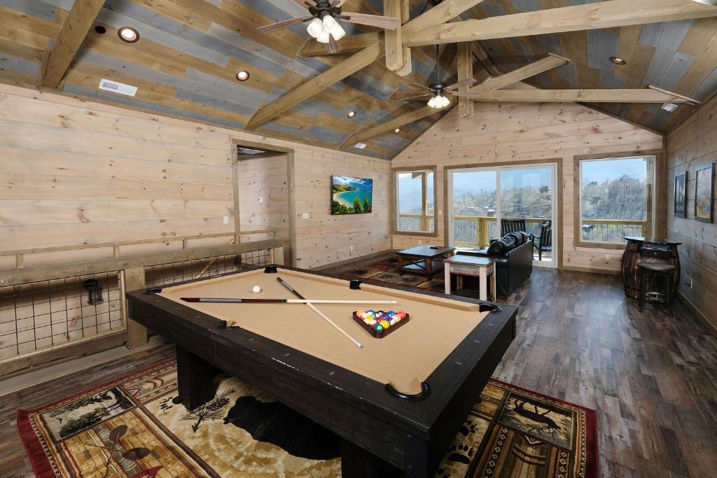 The pool table and lounge under a timber ceiling · © Splash 'N Heavenly Views