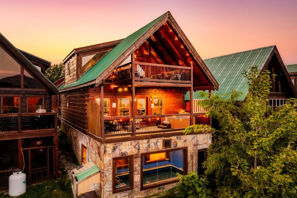 The cabin at dusk, the pool room glowing below the deck · © Splashtacular