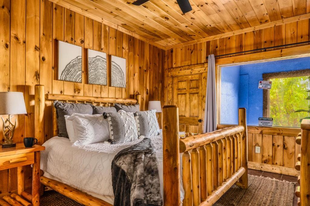 A log-bed bedroom with a window onto the pool room · © Splashtacular