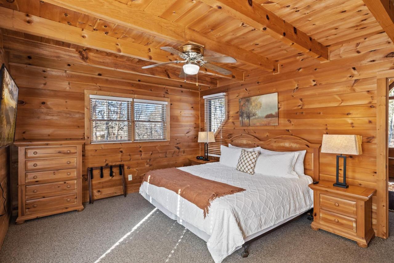 A king bedroom in knotty pine, dressed for the mountains · © SunnySierra Cabin