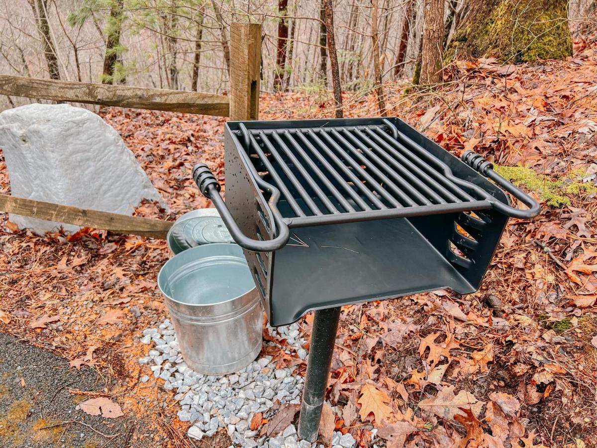 The pedestal grill set out by the trees for cookouts · © SunnySierra Cabin
