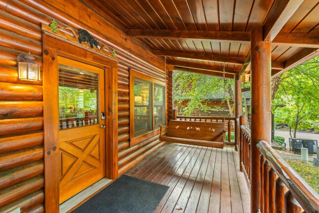 The front porch and its swing under the log eaves · © The Alpenhaus