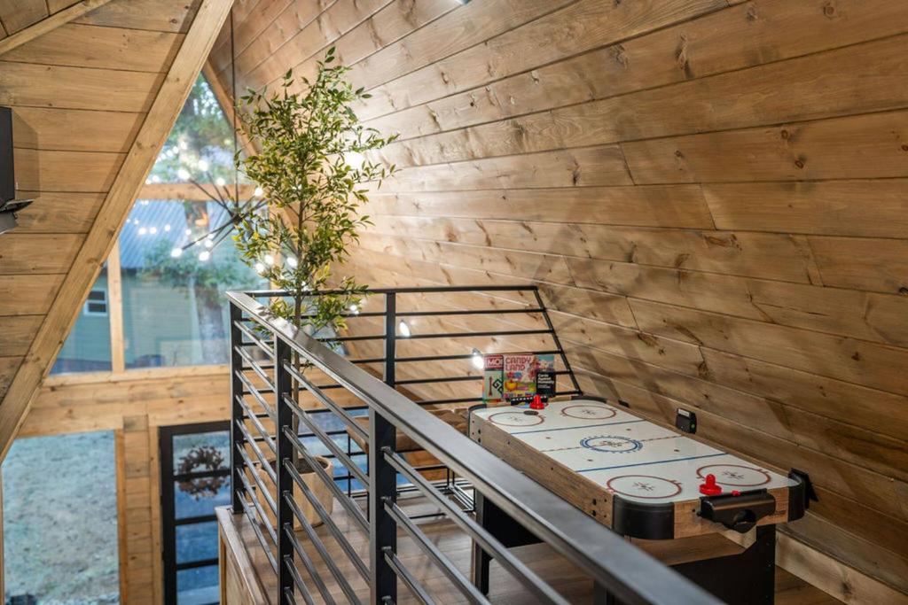 Air hockey in the loft above the glass gable · © The Bold Covemont A-Frame