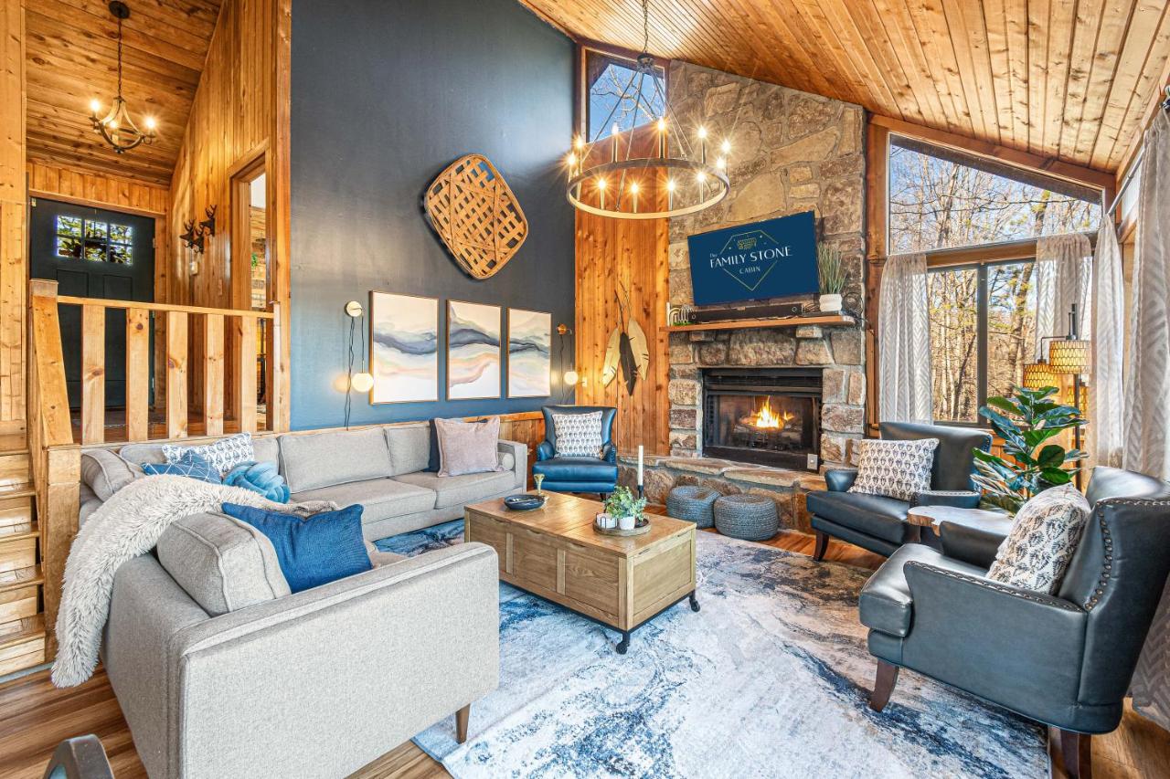 The great room under a vaulted ceiling, gathered around the stone fireplace · © The Family Stone