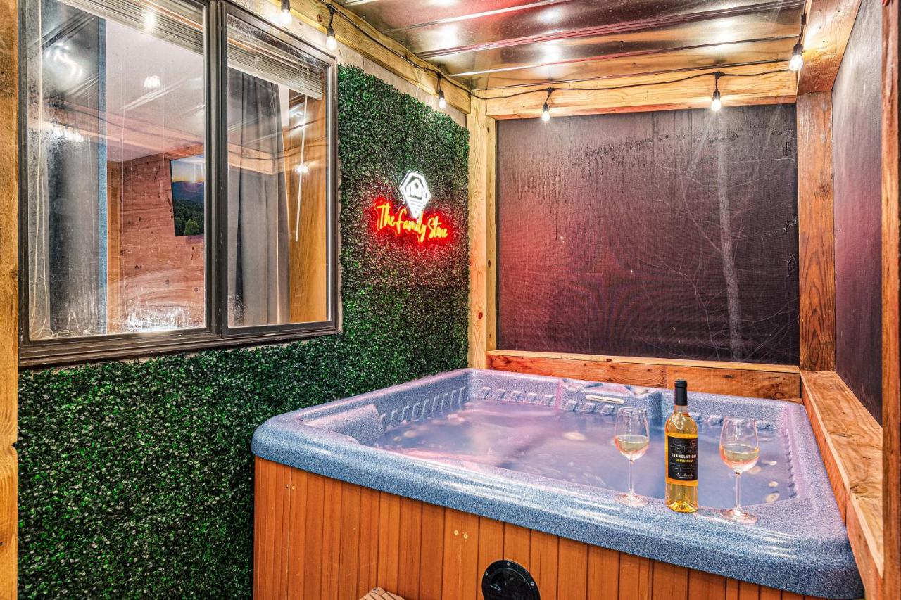 The private hot tub screened on the deck, beneath the cabin's neon sign · © The Family Stone