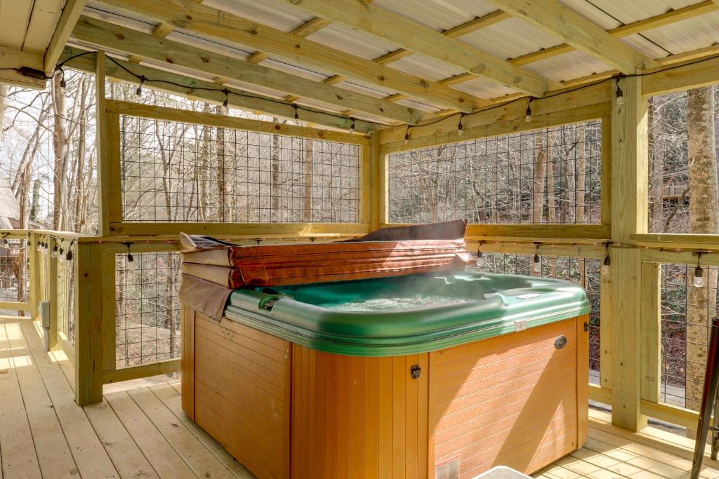 The private hot tub on the covered, light-strung deck · © The Green-Roof A-Frame
